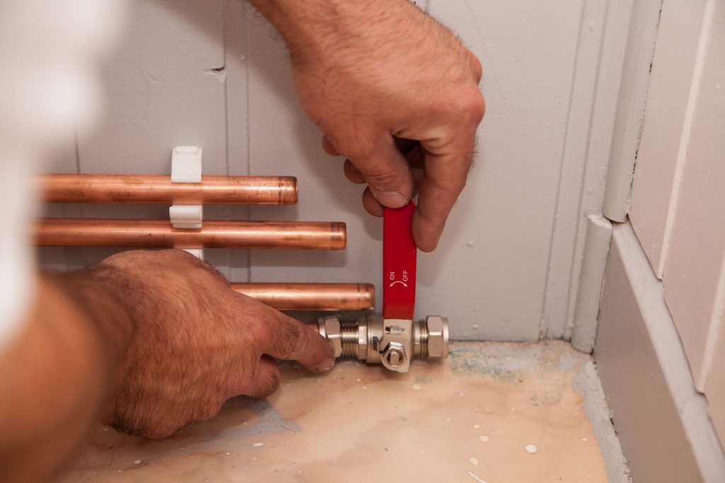 close up image of engineers hands with pipes plumbing A & D Plumbing Services
